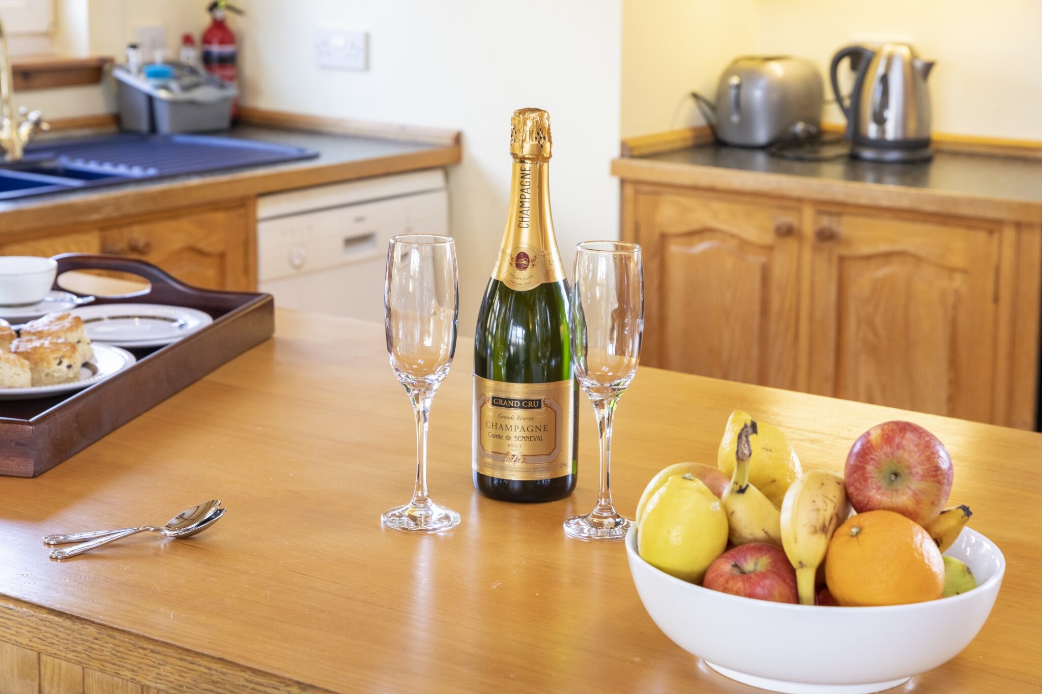 Welcome champagne and fresh fruit arranged on the kitchen counter at Pleasant Hill Scotland, Milngavie