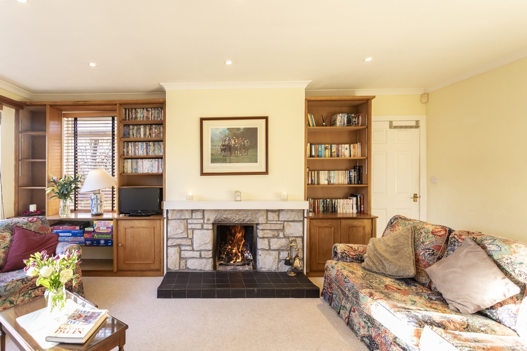 Cosy living room with open fireplace and built-in bookshelves at Pleasant Hill Scotland, a holiday villa near Glasgow